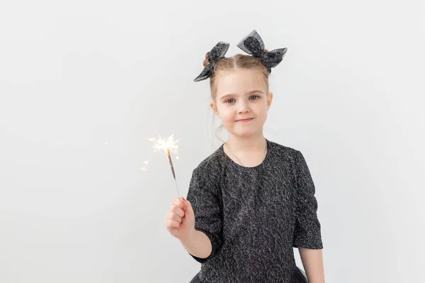 Semester, jul och nyårskoncept - Lyckligt barn håller brinnande tomtebloss i handen över vit bakgrund med kopieringsutrymme — Stockfoto