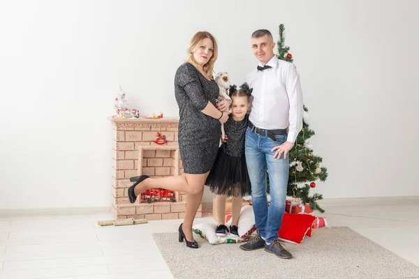 Conceito de feriados - família feliz mãe pai e filho na árvore de Natal em casa — Fotografia de Stock