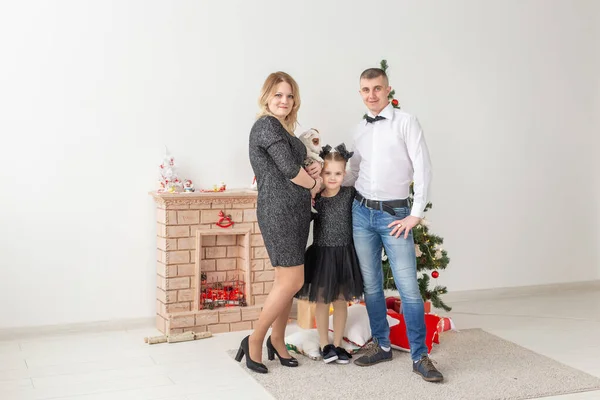 Conceito de feriados - família feliz mãe pai e filho na árvore de Natal em casa — Fotografia de Stock