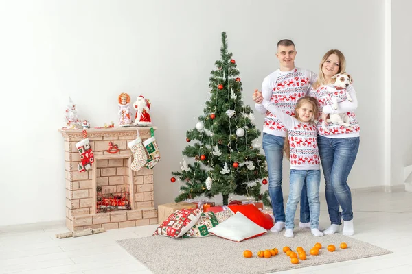 Concepto de vacaciones - feliz familia madre padre e hijo en el árbol de Navidad en casa — Foto de Stock