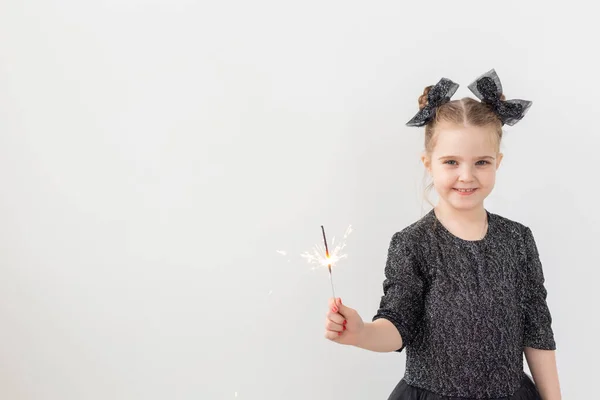 Semester, jul och nyårskoncept - Lyckligt barn håller brinnande tomtebloss i handen över vit bakgrund med kopieringsutrymme — Stockfoto