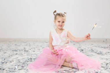 Tatiller, Noel, doğum günü partisi ve yeni yıl konsepti, elinde yanan maytap tutan çocuk. Komik bir partiden sonra.