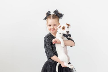 Evcil hayvan ve hayvan kavramı - Jack Russell Terrier köpekle oynayan kız çocuk.