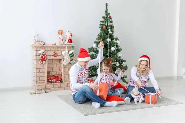 Urlaub und Geschenke-Konzept - Porträt einer glücklichen Familie, die zu Weihnachten Geschenke öffnet — Stockfoto