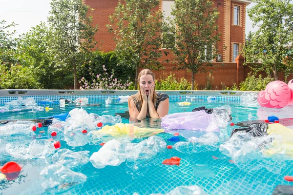 Ecologie, plastic afval, milieu noodsituatie en watervervuiling - Schreeuwende vrouw met een plastic zak over zijn hoofd in een vies zwembad — Stockfoto