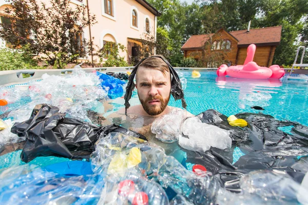 Ecology, plastic trash, environmental emergency and water pollution - shocked man swim in a dirty swimming pool