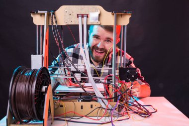 Teknoloji ve mühendislik konsepti - Laboratuvarda gece çalışan erkek mühendis, 3D yazıcı bileşenlerini ayarlıyor.