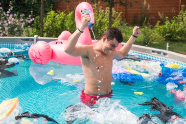 Ekoloji, plastik çöp, çevresel acil durum ve su kirliliği - kirli bir yüzme havuzunda duran şok adam