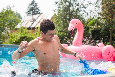 Ekoloji, plastik çöp, çevresel acil durum ve su kirliliği - kirli bir yüzme havuzunda duran şok adam