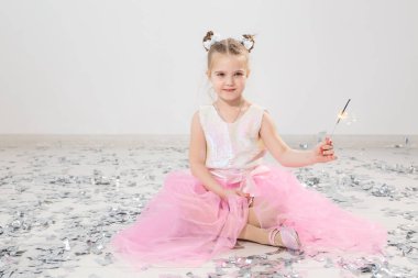 Tatiller, Noel, doğum günü partisi ve yeni yıl konsepti, elinde yanan maytap tutan çocuk. Komik bir partiden sonra.