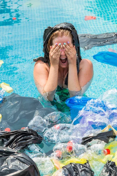 Ecologia, lixo plástico, emergência ambiental e poluição da água - Mulher gritando com um saco de plástico sobre a cabeça em uma piscina suja — Fotografia de Stock