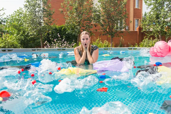 Ecologia, lixo plástico, emergência ambiental e poluição da água - Mulher gritando com um saco de plástico sobre a cabeça em uma piscina suja — Fotografia de Stock