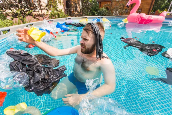 Ecologie, plastic afval, milieu noodsituatie en watervervuiling - geschokte man zwemmen in een vies zwembad — Stockfoto