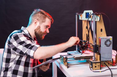 Teknoloji ve mühendislik konsepti - Laboratuvarda gece çalışan erkek mühendis, 3D yazıcı bileşenlerini ayarlıyor.