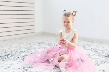 Tatiller, Noel, doğum günü partisi ve yeni yıl konsepti, elinde yanan maytap tutan çocuk. Komik bir partiden sonra.