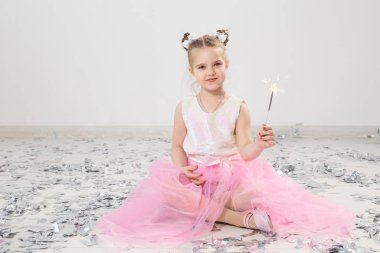 Tatiller, Noel, doğum günü partisi ve yeni yıl konsepti, elinde yanan maytap tutan çocuk. Komik bir partiden sonra.