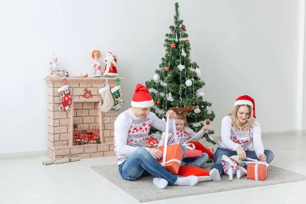 Vacaciones y presenta el concepto - Retrato de una familia feliz regalos de apertura en época de Navidad — Foto de Stock