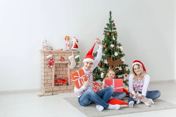 Férias e apresenta conceito - Retrato de uma família feliz sentada com presentes no tempo de Natal — Fotografia de Stock
