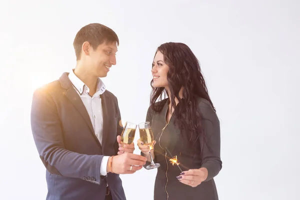 Concetto giorno e data di San Valentino - Coppia con bicchieri di champagne e scintille su sfondo bianco — Foto Stock