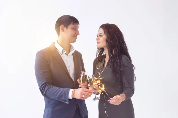 Conceito de dia e data dos namorados - Casal com taças de champanhe e brilhos no fundo branco — Fotografia de Stock