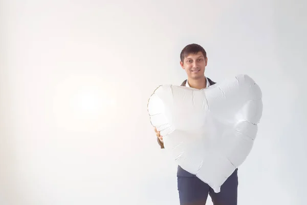 Schöner Mann mit herzförmigem Luftballon auf weißem Hintergrund mit Kopierraum. Mann am Valentinstag. — Stockfoto