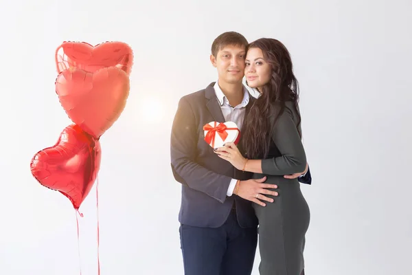 Valentines day, holiday and gift concept. Happy young couple with valentines day present isolated on a white background. Happy Man giving a gift to his girlfriend. — 스톡 사진