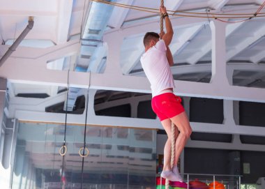 Fitness halatı tırmanma egzersizi spor salonunda.