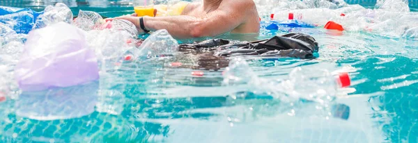 Ecology, plastic trash, environmental emergency and water pollution - shocked man swim in a dirty swimming pool