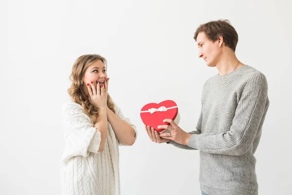 Valentýn, sváteční a dárkový koncept. Šťastný mladý pár s Valentýna dárek izolované na bílém pozadí. Šťastný muž dává dárek své přítelkyni. — Stock fotografie