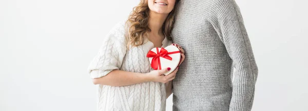 Alla hjärtans dag, semester och presentkort. Närbild av par med alla hjärtans dag närvarande isolerad på en vit bakgrund. Happy Man ger en gåva till sin flickvän. — Stockfoto