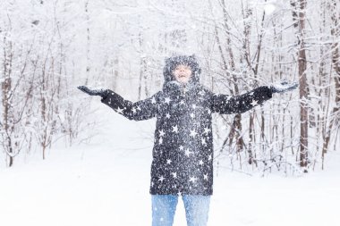 Mutlu genç kız bir kış ormanında kar kusuyordu.