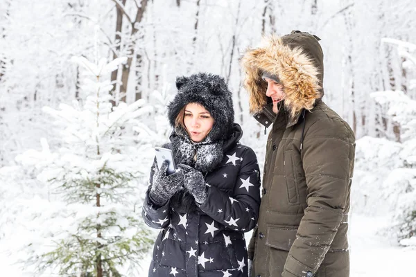 Temporada, amor, tecnologia e conceito de lazer - casal feliz tomando selfie por smartphone sobre fundo de inverno — Fotografia de Stock