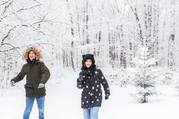 재미, 계절 및 여가 개념 - 사랑하는 부부는 눈 위에서 겨울 장작을 연주 한다 — 스톡 사진