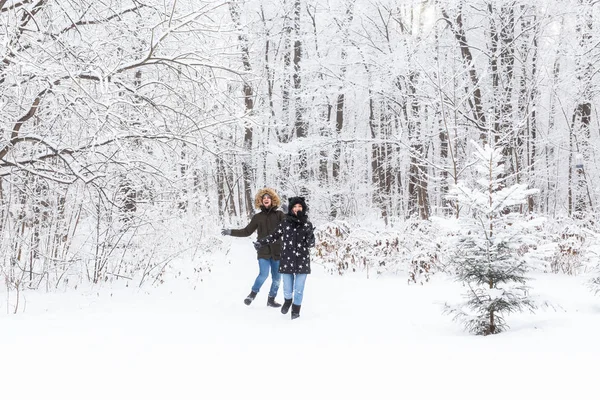 Joyeux couple marchant dans une forêt enneigée en hiver — Photo