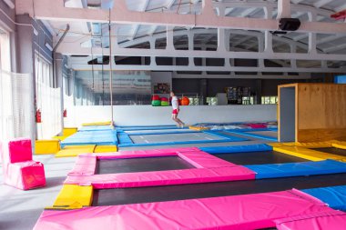 Fitness, eğlence, eğlence ve spor aktivite konsepti - Yakışıklı mutlu adam kapalı bir trambolin üzerinde atlama