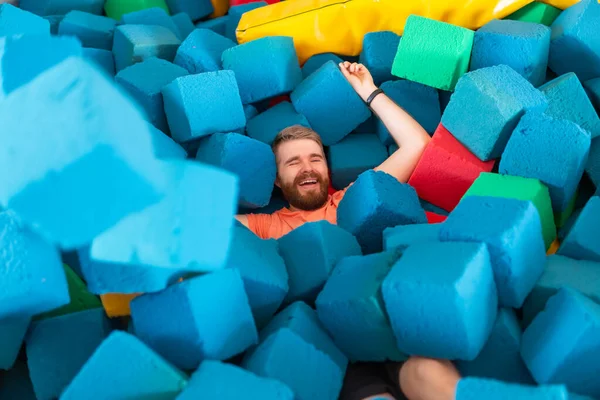 Fitness, fun, leisure en sport activity concept - Grappige vrolijke man die plezier heeft op een trampoline binnen — Stockfoto