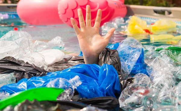 プラスチック汚染と環境問題、プラスチック海の人間の手 — ストック写真