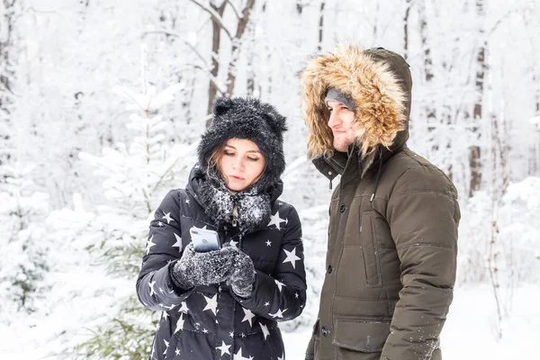 Saison, amour, technologie et concept de loisirs - couple heureux prenant selfie par smartphone sur fond d'hiver — Photo