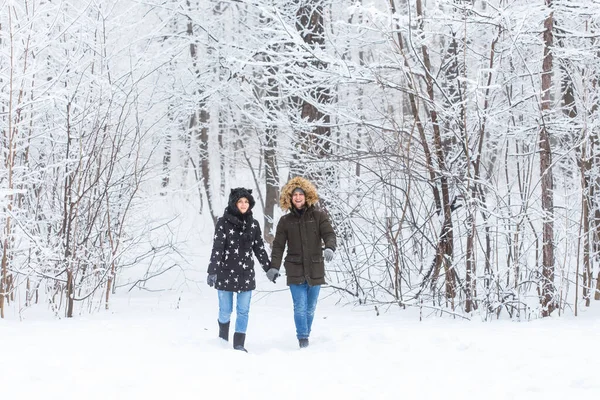 Jeune couple amoureux se promène dans la forêt enneigée. Vacances d'hiver actives. — Photo