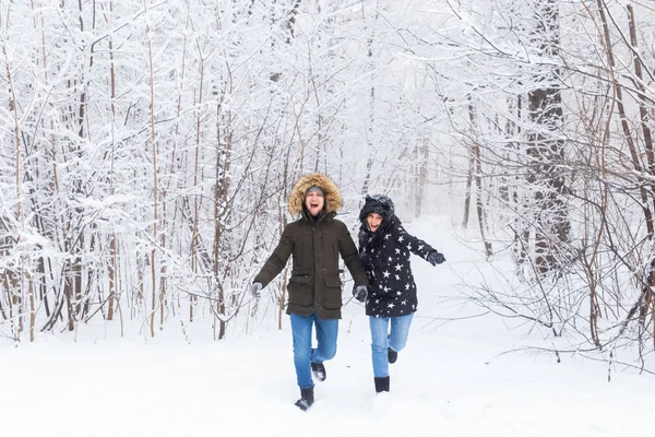 Joyeux couple marchant dans une forêt enneigée en hiver — Photo