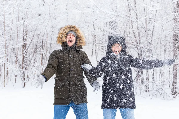 Heureux jeune couple vomir une neige dans une forêt d'hiver — Photo