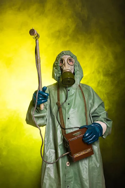 Conceito de radiação, poluição e perigo - Homem de roupa protetora e máscara de gás sobre fundo escuro — Fotografia de Stock