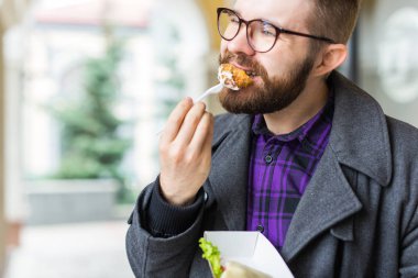 Man holding one-off plate with traditional delicious jewish food falafel made of chickpeas at the street food festival