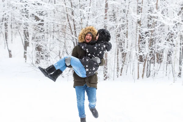 Feliz casal amoroso se divertindo ao ar livre no parque de neve. Férias inverno — Fotografia de Stock