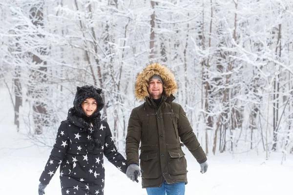 Młoda para spacerująca po śnieżnym parku. Sezon zimowy. — Zdjęcie stockowe