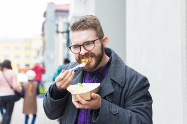 Man holding one-off plate with traditional delicious jewish food falafel made of chickpeas at the street food festival