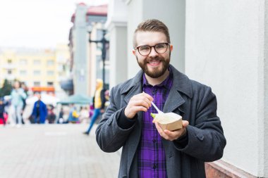 Man holding one-off plate with traditional delicious jewish food falafel made of chickpeas at the street food festival