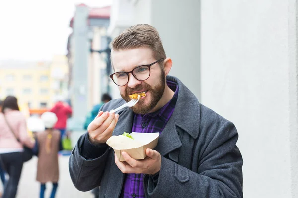 Man holding one-off plate with traditional delicious jewish food falafel made of chickpeas at the street food festival — ストック写真