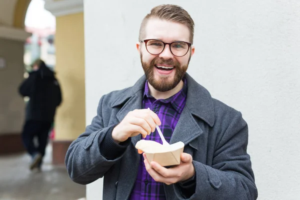 Hombre sosteniendo un plato único con comida judía tradicional falafel hecho de garbanzos en el festival de comida callejera. Comida vegetariana frita muy sabrosa . — Foto de Stock