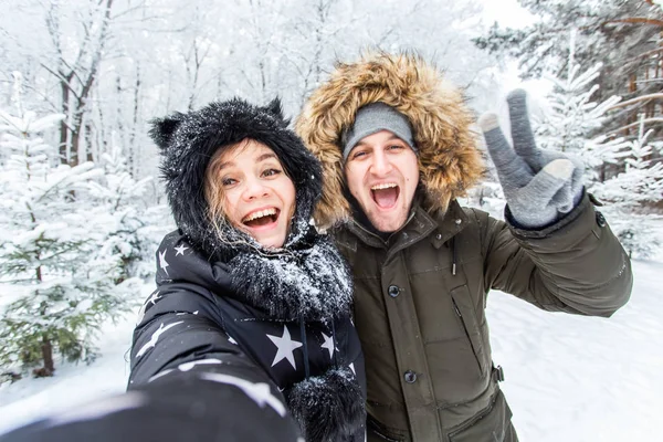 Stagione e concetto di relazione - Coppia divertente scattare selfie nel periodo invernale — Foto Stock